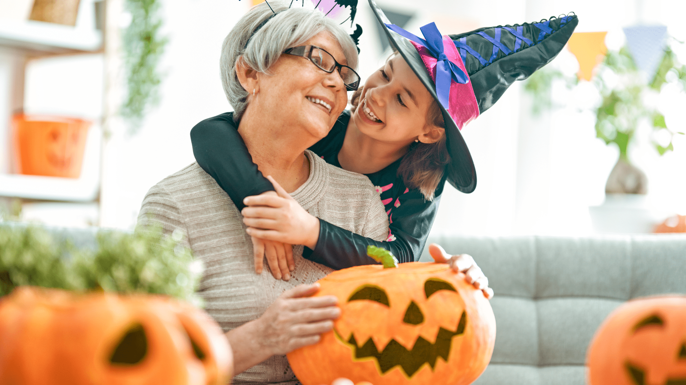 Elderly woman and granddaughter with Halloween witch costume and pumpkins